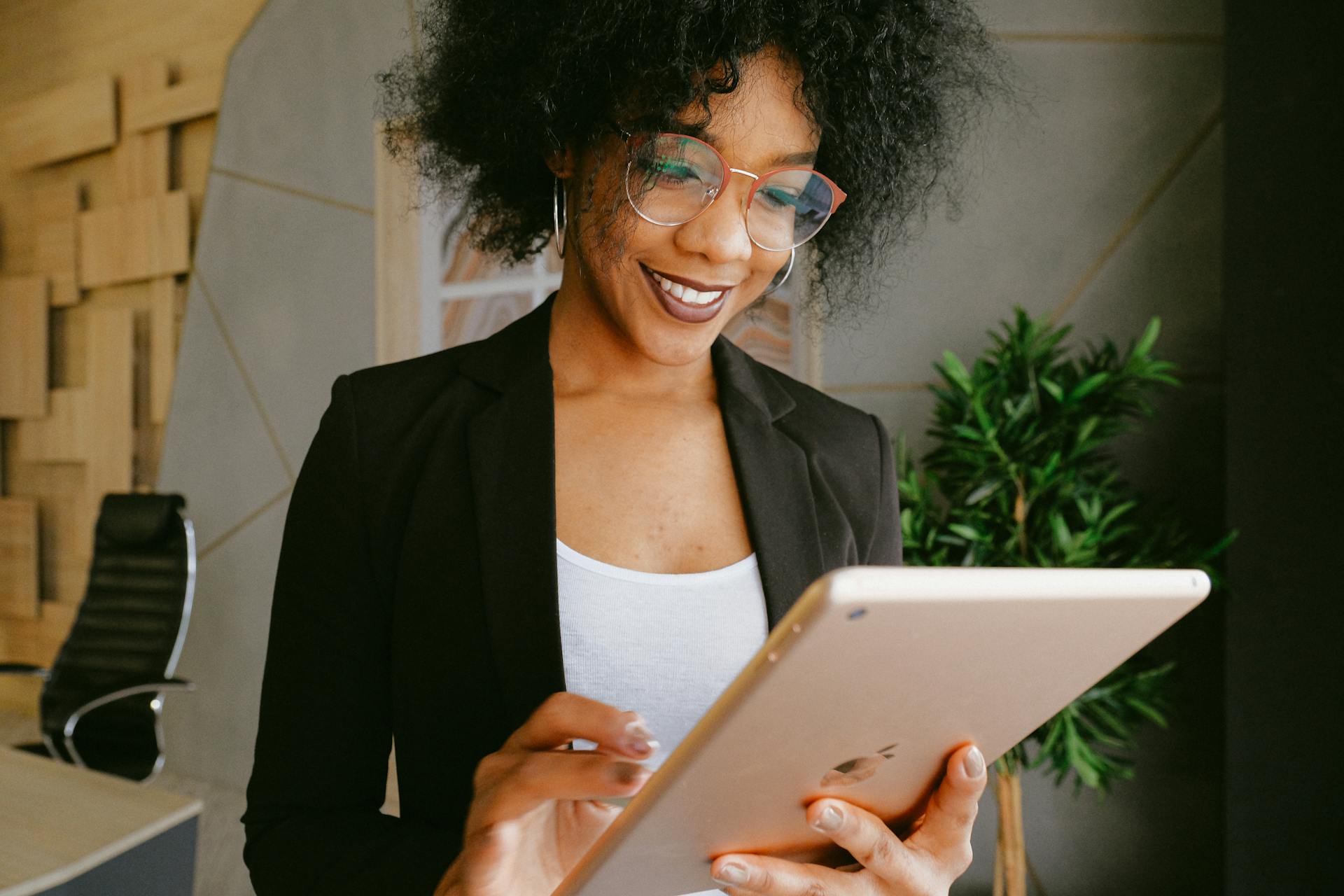 Mujer de negocios con gafas utilizando una tableta.